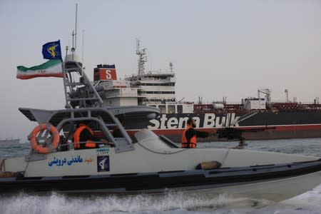 A boat of Iranian Revolutionary Guard sails next to Stena Impero, a British-flagged vessel owned by Stena Bulk, at Bandar Abbas port