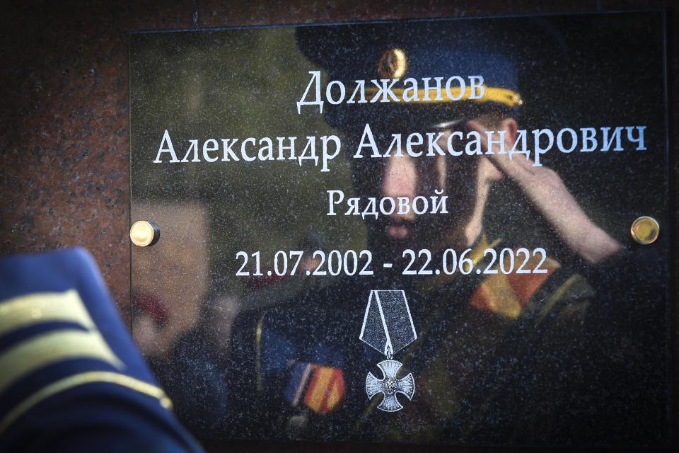 FILE - A student of a military school salutes standing in front of a plaque with the name of Russian soldier Alexander Dolzhanov, who died during the Russian Special military operation in Ukraine, attached on the memorial "Hill of Glory" in Yalta, Crimea, Friday, Feb. 24, 2023. Nearly 50,000 Russian soldiers have died in the war in Ukraine, according to the first independent statistical analysis of Russia’s war dead. (AP Photo, File)