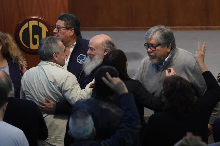 Emilio Pérsico y Fernando "Chino" Navarro, al llegar a la CGT. Saludan al gremialista Juan Carlos Schmid 