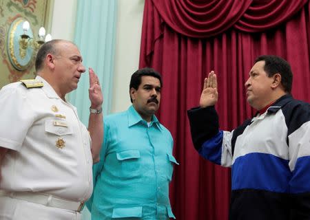 FILE PHOTO: Venezuela's President Hugo Chavez takes an oath to Admiral Diego Alfredo Molero (L) as Vice President Nicolas Maduro (C) looks on, at Miraflores Palace in Caracas, Venezuela, December 10, 2012. Miraflores Palace/Handout via REUTERS/File Photo