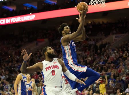 Dec 10, 2018; Philadelphia, PA, USA; Philadelphia 76ers center Joel Embiid (21) scores past Detroit Pistons center Andre Drummond (0) during the third quarter at Wells Fargo Center. Bill Streicher-USA TODAY Sports