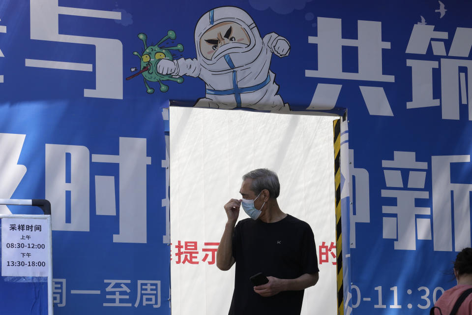 A resident leaves from a mass COVID test site, Friday, May 27, 2022, in Beijing. (AP Photo/Ng Han Guan)