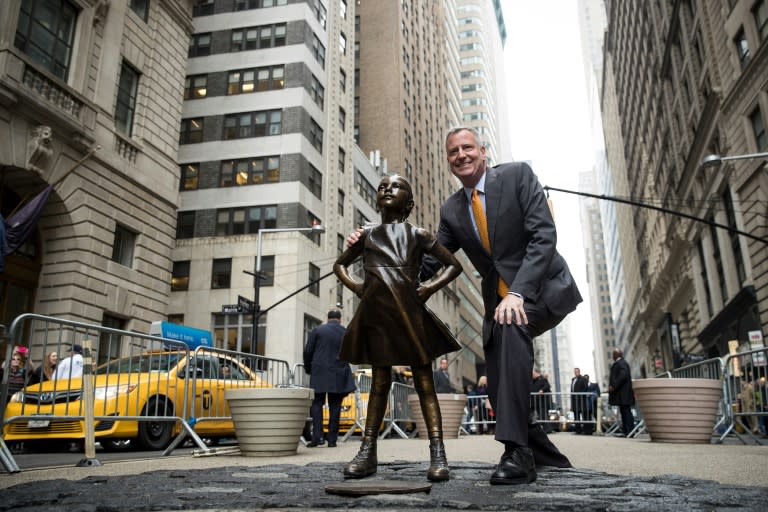 New York City Mayor Bill De Blasio poses for a photo with the "Fearless Girl" statue in New York City