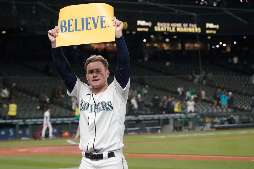 Seattle Mariners' Jarred Kelenic holds up a sign that read "Believe" after the Mariners beat the Oakland Athletics, 4-2, Sept. 29. Fans and the team adopted the one-word slogan that was recently featured on the TV series "Ted Lasso" as the Mariners battled for a spot in the MLB playoffs.