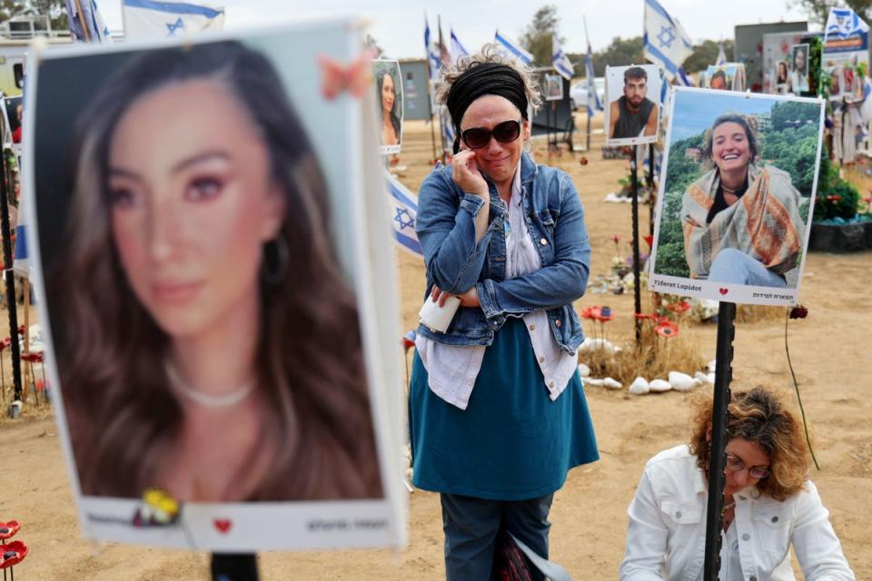 Visitors at a memorial for those taken hostage or killed in the Hamas attack on the Supernova music festival on 7 October (AFP via Getty Images)