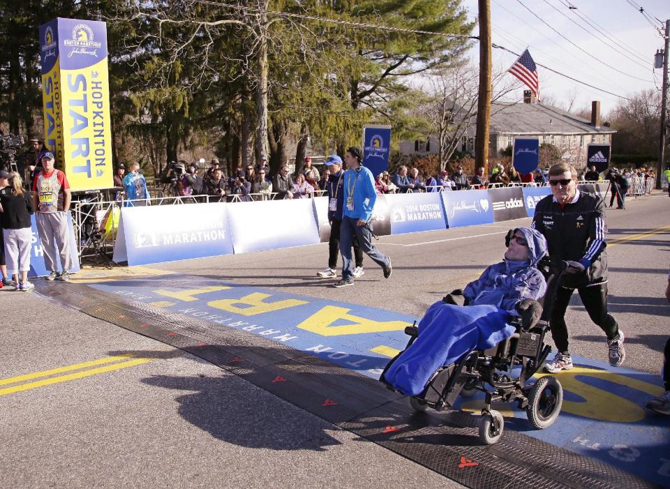 Father and son Boston Marathon race team Dick Hoyt, right, and his son Rick Hoyt walk across the start line as they warm up before they run the 118th Boston Marathon Monday, April 21, 2014 in Hopkinton, Mass. (AP Photo/Stephan Savoia)