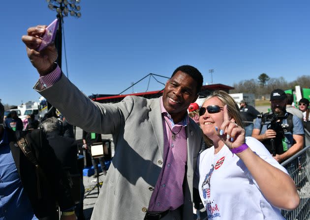 Republican Senate candidate Herschel Walker and a woman take a selfie during former President Donald Trump's 