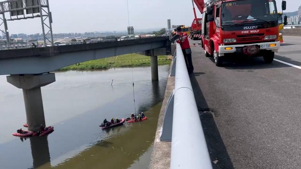 大型吊車將墜河轎車吊上路面。讀者提供