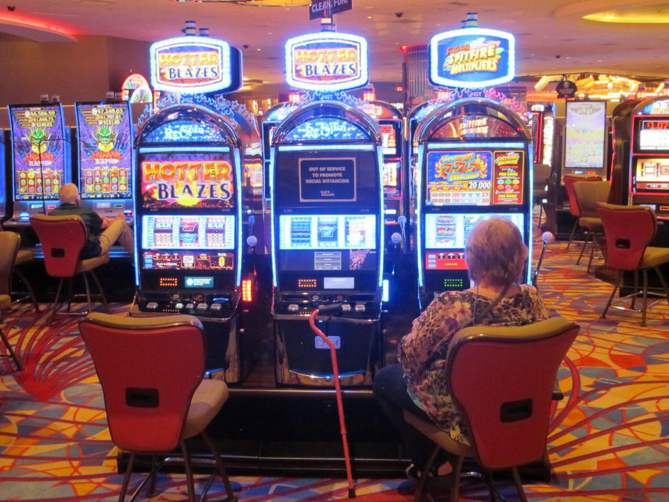 This May 3, 2021 photo shows a woman playing a slot machine at the Hard Rock casino in Atlantic City N.J. On Monday, May 24, 2021, New Jersey gambling regulators released figures showing that the Atlantic City casinos' first quarter earnings more than tripled this year compared to the same period last year, when the COVID19 pandemic wiped out half of March.(AP Photo/Wayne Parry)