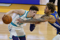 Charlotte Hornets guard LaMelo Ball, left, is defended by Golden State Warriors guard Kelly Oubre Jr. during the first half of an NBA basketball game in San Francisco, Friday, Feb. 26, 2021. (AP Photo/Jeff Chiu)