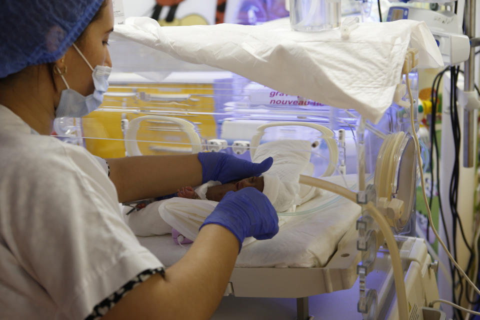 A Moroccan nurse takes care of one of the nine babies protected in an incubator at the maternity unit of the Ain Borja clinic in Casablanca, Morocco, Thursday May 20, 2021, two weeks after Mali's Halima Cisse, 25, gave birth to nine healthy babies. (AP Photo / Abdeljalil Bounhar)