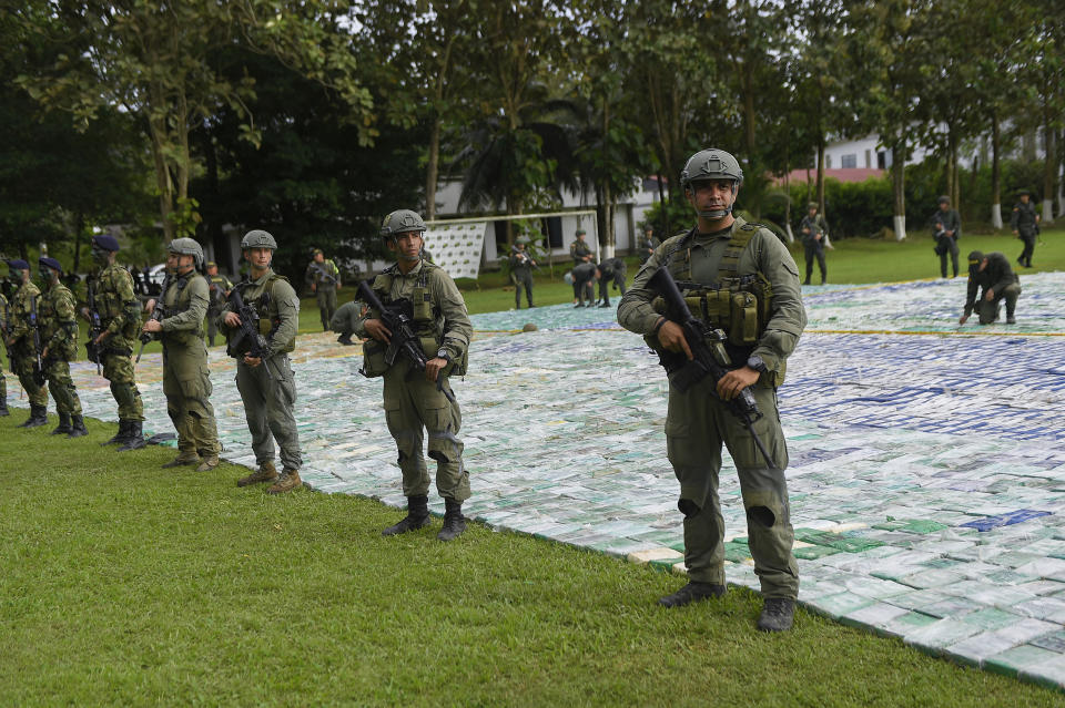 Imagen distribuida por la Presidencia colombiana que muestra a policías antinarcóticos junto a un alijo de 12 toneladas de cocaína, el 8 de noviembre de 2017 en Apartado (Colombia) (Colombian Presidency/AFP | HO)