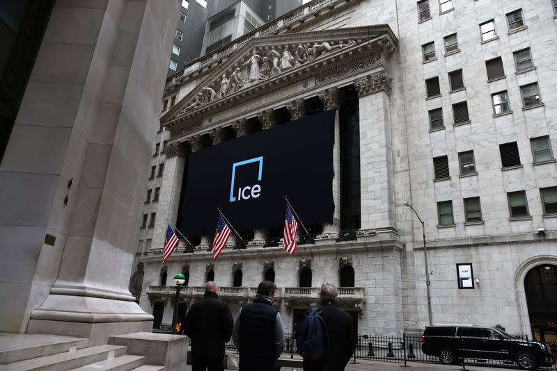 People stand by the New York Stock Exchange (NYSE) in New York City