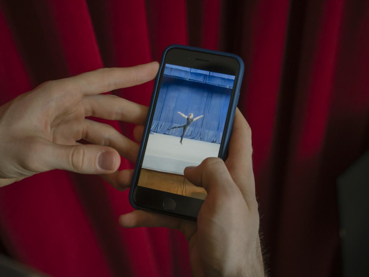 Martin Korol shows a video of himself dancing from his phone.