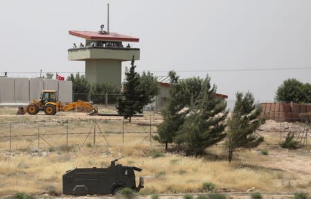 FILE PHOTO: Turkish soldiers stand on a watchtower at the Atmeh crossing on the Syrian-Turkish border, as seen from the Syrian side, in Idlib governorate, Syria