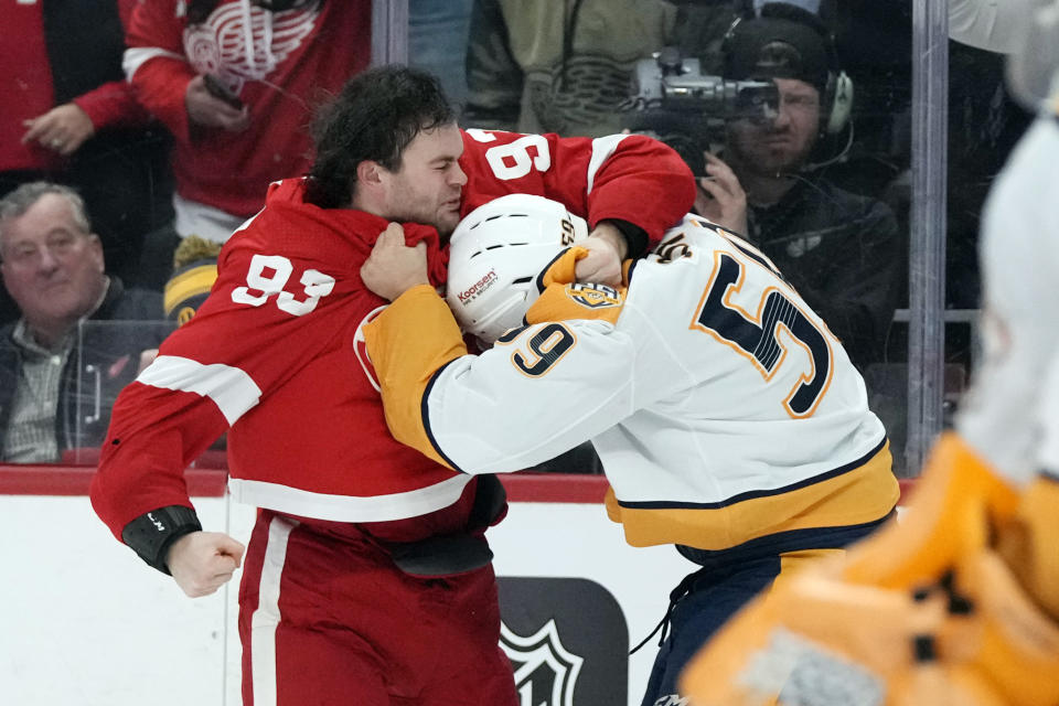 Detroit Red Wings right wing Alex DeBrincat (93) fights Nashville Predators defenseman Roman Josi (59) during the second period of an NHL hockey game, Friday, Dec. 29, 2023, in Detroit. (AP Photo/Carlos Osorio)