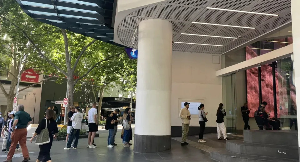 People queue to gain entry to a Telstra store in Melbourne.