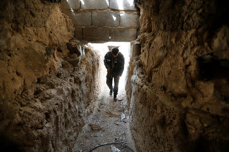 A fighter from the Iraqi Shi'ite Badr Organization holds his rifle in an underground tunnel built by Islamic State fighters on the outskirts of Falluja, Iraq, May 28, 2016. REUTERS/Thaier Al-Sudani