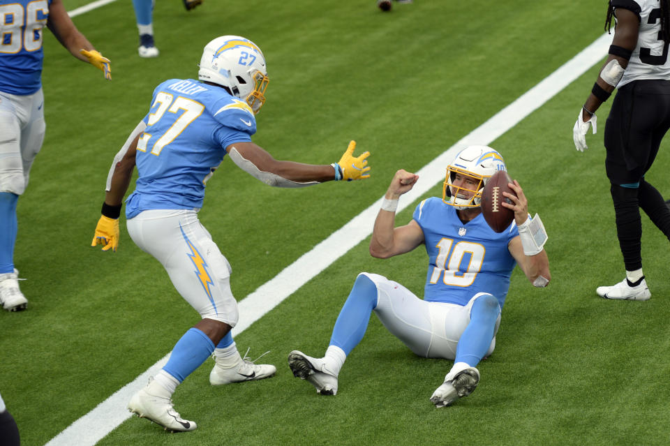 Los Angeles Chargers quarterback Justin Herbert (10) celebrates his rushing touchdown with Joshua Kelley (27) during the second half of an NFL football game against the Jacksonville Jaguars Sunday, Oct. 25, 2020, in Inglewood, Calif. (AP Photo/Kyusung Gong)