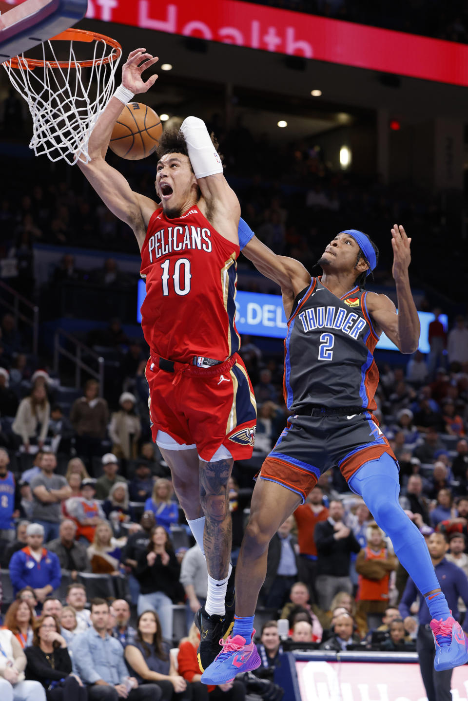 New Orleans Pelicans center Jaxson Hayes (10) is fouled by Oklahoma City Thunder guard Shai Gilgeous-Alexander (2) during the second half of an NBA basketball game Friday, Dec. 23, 2022, in Oklahoma City. (AP Photo/Garett Fisbeck)