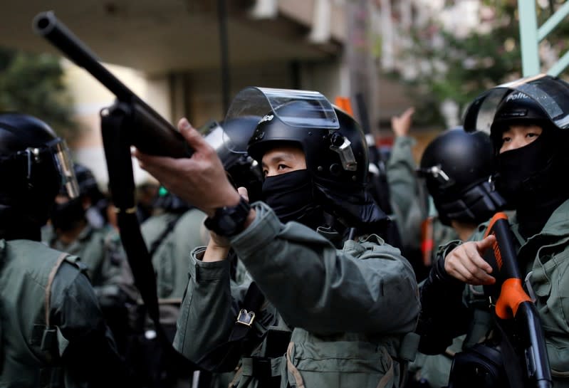 A police officer points his weapon during an anti-government demonstration in Hong Kong, China