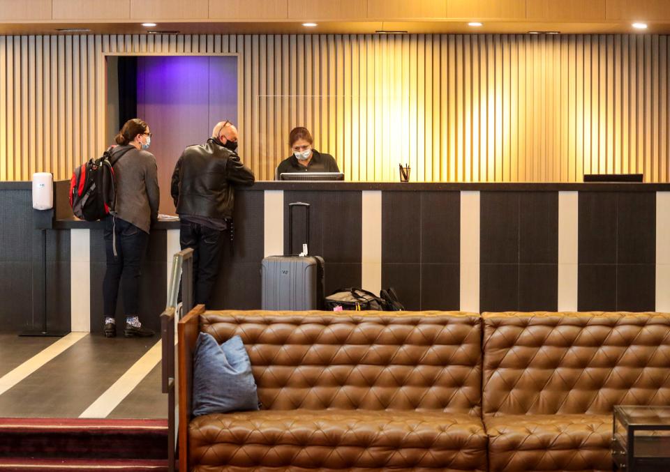 Front desk supervisor Chela Tamayo checks out guests at Hotel Zoso, Jan. 13, 2022, in Palm Springs. The hotel has had difficulty finding workers to fill front desk positions at the hotel for the last year.