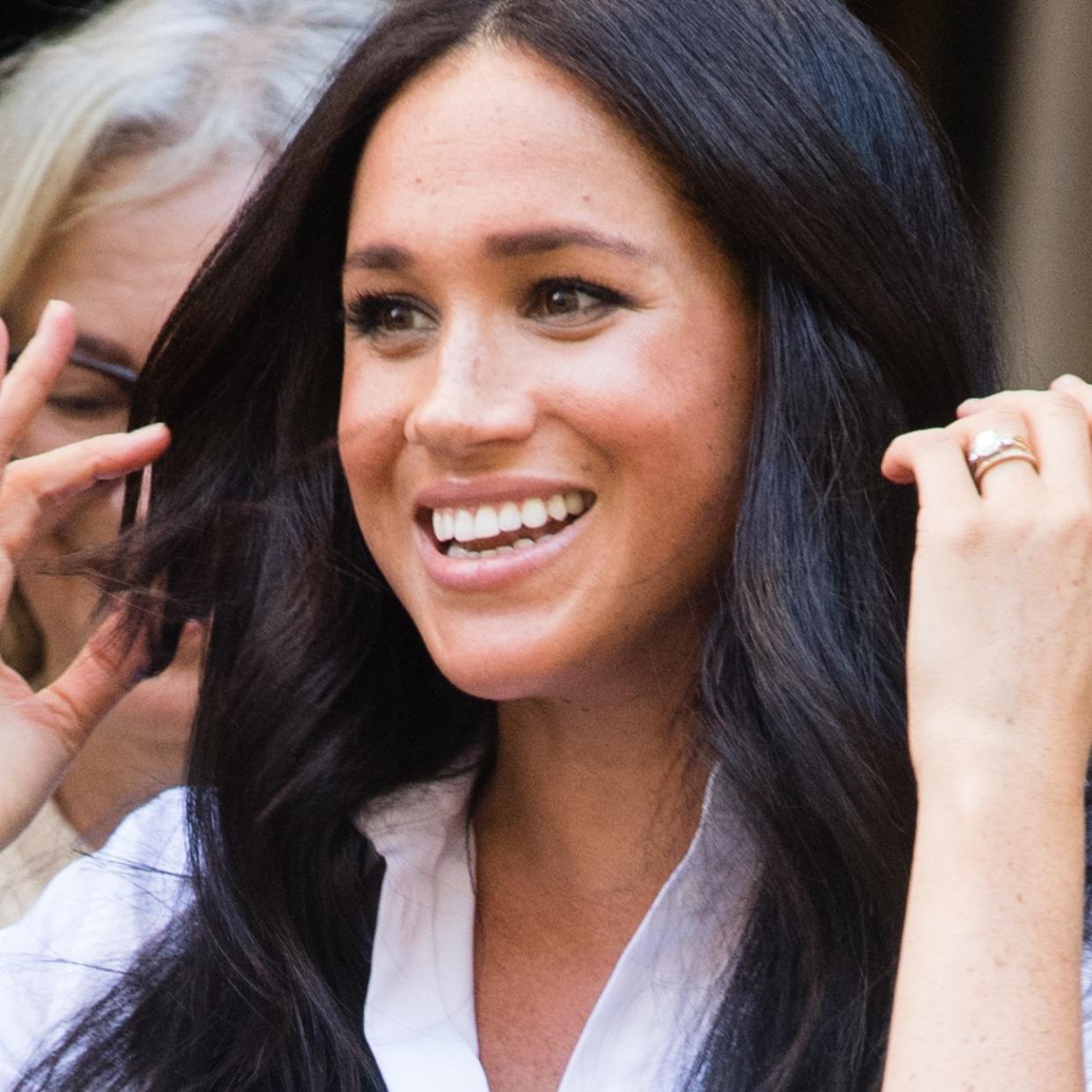  Meghan Markle pushes her hair away from her face 