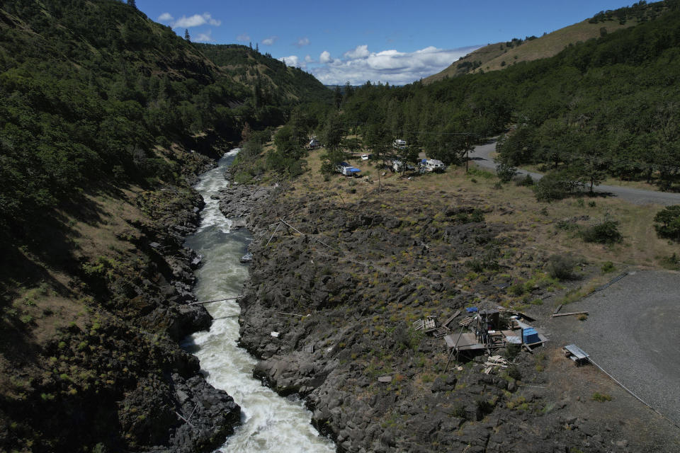 Water rushes through Lyle Falls in the Klickitat River, a tributary that runs into the Columbia River, on Sunday, June 19, 2022, in Lyle, Wash. For generations, Indigenous people have fished for salmon and trout from scaffolds perched just above the sacred water. (AP Photo/Jessie Wardarski)