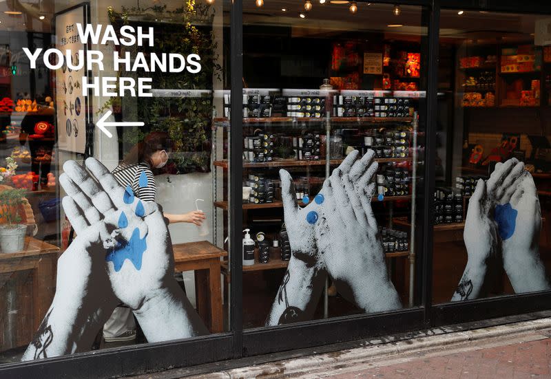 A shop employee wearing a protective face mask, following an outbreak of the coronavirus disease (COVID-19), prepares antiseptic solution at Shibuya shopping and amusement district in Tokyo