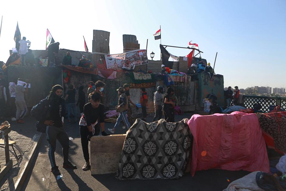 Anti-government protesters stage a sit-in on the Ahrar Bridge, in Baghdad, Iraq, Wednesday, Nov. 20, 2019. Iraqi security officials say at least 27 protesters have been wounded in renewed clashes overnight in central Baghdad. (AP Photo/Khalid Mohammed)