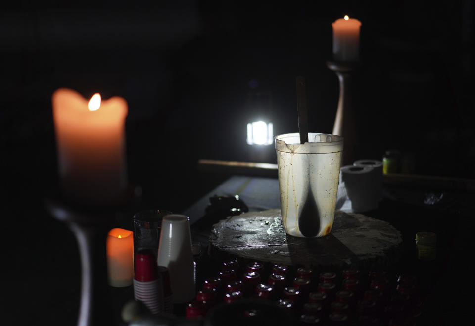 An empty pitcher and shot sized cups sit on an altar during an ayahuasca ceremony hosted by Hummingbird Church in Hildale, Utah, on Friday, Oct. 14, 2022. Ayahuasca is a psychoactive brew that contains an Amazon shrub with the active ingredient, DMT, and a vine containing monoamine oxidase inhibitors that prevents the drug from breaking down in the body causing visions lasting several hours. (AP Photo/Jessie Wardarski)