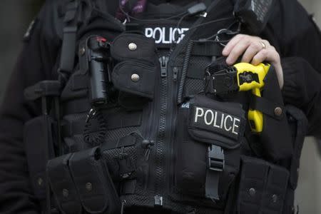 An armed police officer rests his hand on a taser outside the Ministry of Defence in London, Britain November 18, 2015. REUTERS/Neil Hall