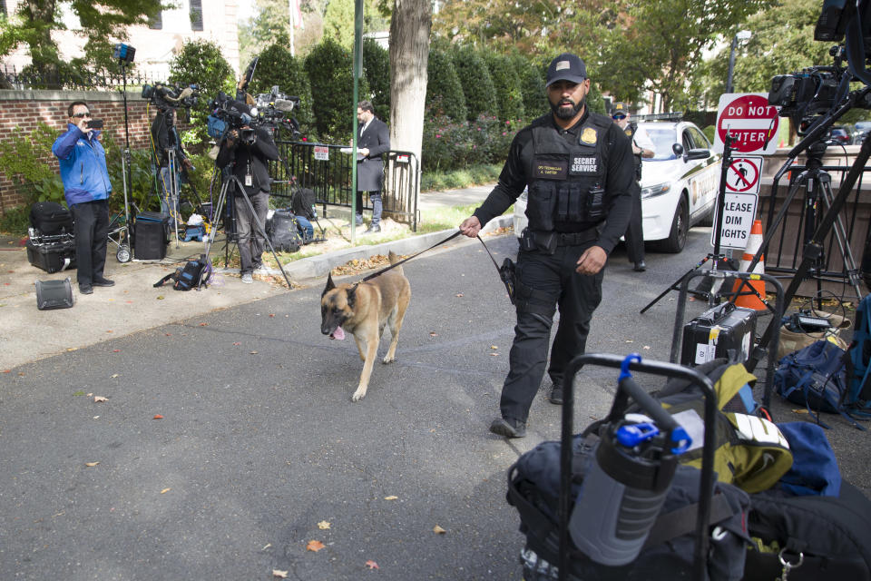 <em>An officer with the Uniform Division of the United States Secret Service uses his dog to search a checkpoint near the home of President Barack Obama (AP)</em>