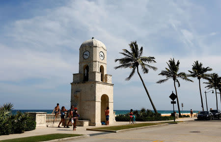 Beachgoers walk along Ocean Ave. near the Mar-a-Lago estate in Palm Beach, Florida, U.S., April 5, 2017. U.S. President Donald Trump will meet with President of China Xi Jinping on April 6 and 7 at the estate. REUTERS/Joe Skipper