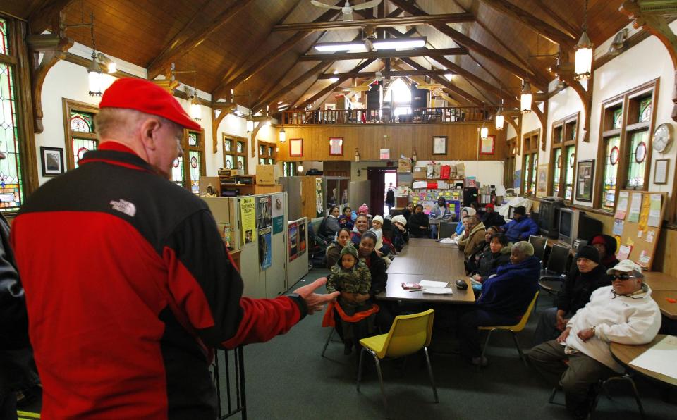 A wealthy philanthropist from Kansas City, Mo., known as Secret Santa, distributes $100 dollar bills to needy people at St. Joseph's Social Service Center in Elizabeth, N.J., Thursday, Nov. 29, 2012. (AP Photo/Rich Schultz)