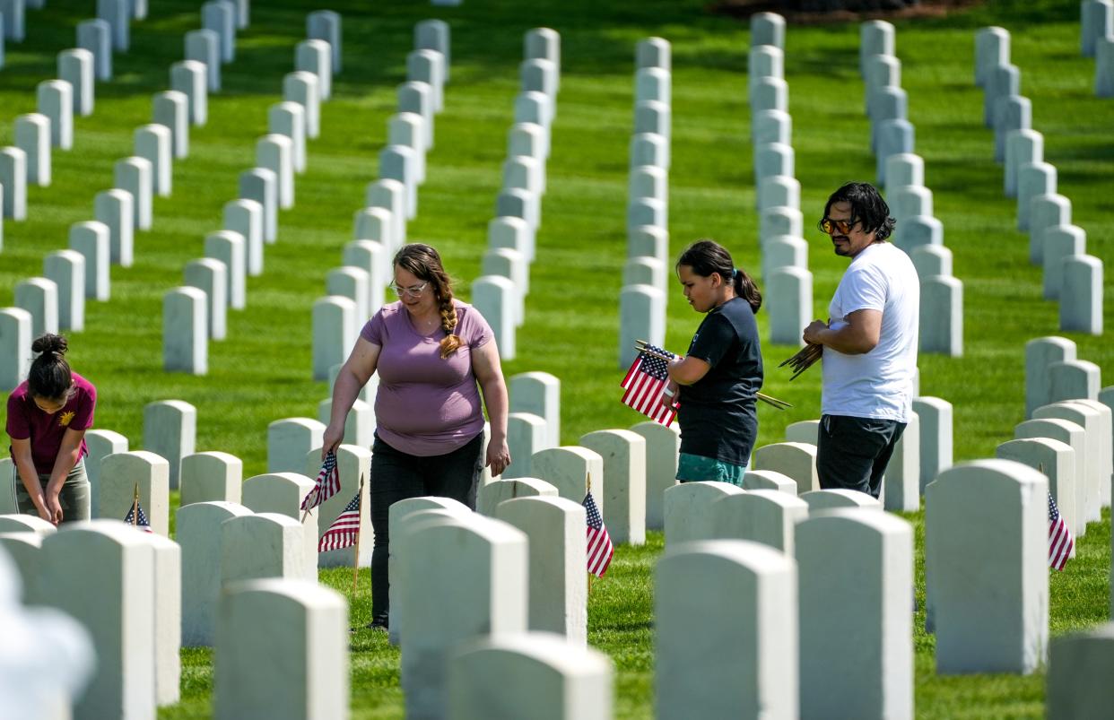 Families and other volunteers on Saturday, May 28, 2022 place thousands of flags at veterans' gravesites at Wood National Cemetery ahead of Memorial Day. Milwaukee's public Memorial Day ceremony returns this year and will be held Monday, May 30.