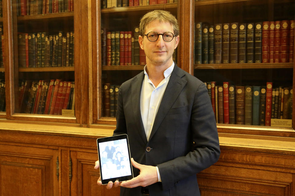 Ariel Weil holds in a library in Paris city hall on Tuesday, Oct.12, 2021 a photo of his great-uncle Andre Baur and all of his family who were deported together from Drancy and murdered in Auschwitz. When André Baur's great-nephew, a Paris mayor, was catching up on his Twitter feed recently and saw a claim widely reported in French mainstream media that Adolf Hitler's Vichy collaborators had saved France's Jews from the Holocaust, he was swept with anger and revulsion. Worst still in the eyes of Weil, was that the debunked assertion came from a pretender for the French presidency who is himself Jewish. That person is Eric Zemmour, a rabble-rousing television pundit and author with repeated convictions for hate speech who is finding fervent audiences for his anti-Islam, anti-immigration invective in the early stages of France's presidential race. (AP Photo/John Leicester)