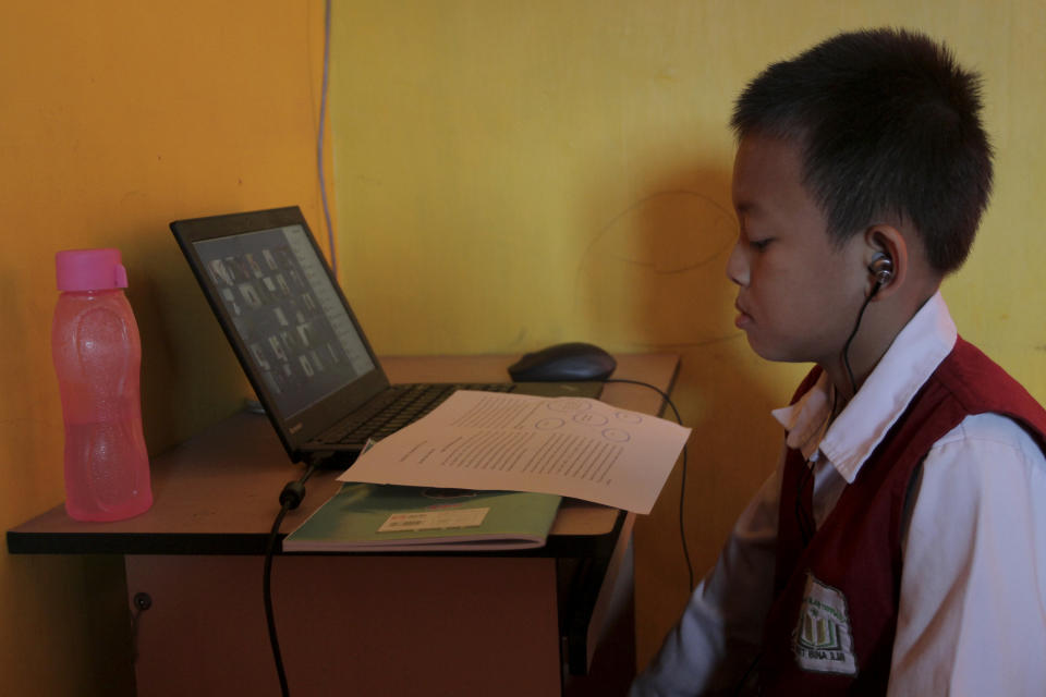 A student studies at his house in Palembang, South Sumatra, Indonesia, Monday, Oct. 2, 2023. Officials on Indonesia’s Sumatra island on Monday asked residents to work from home as more than 300 forest and peatland fires were causing widespread haze in the region. The local government in South Sumatra last week called on schools to delay their opening time, as the haze and smoke tend to decrease as the day goes on. (AP Photo/Muhammad Hatta)