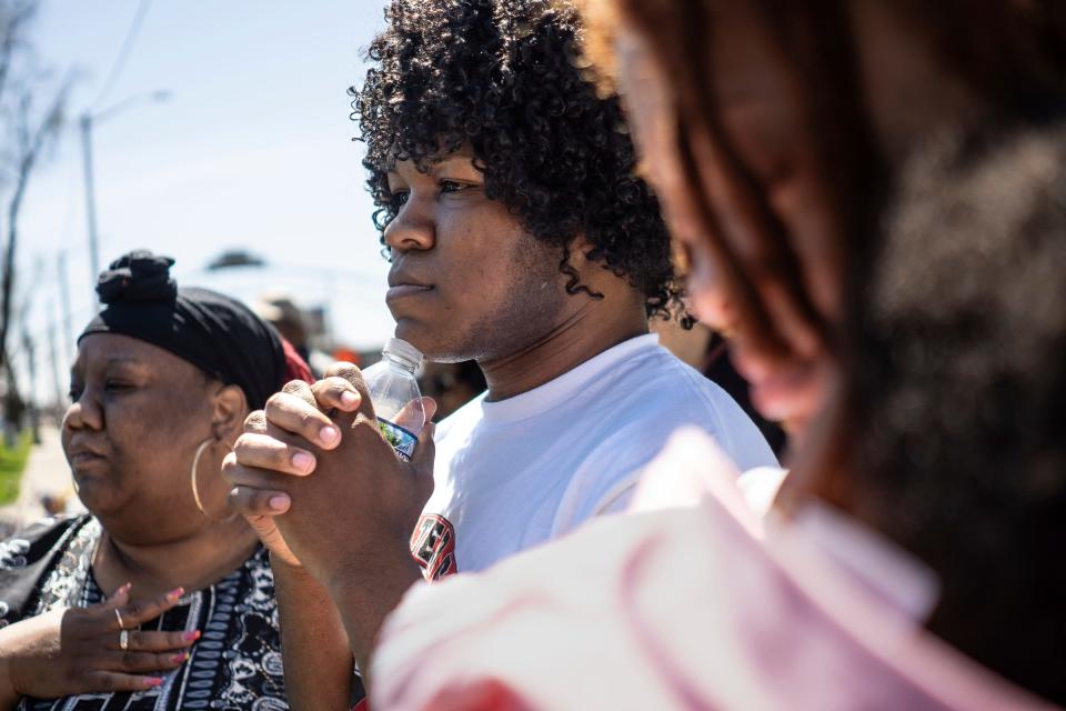 Keishaun Wade, center, of Flint, holds a water bottle while standing with his mother, Tasha Wade, left, of Flint, and Alayna Goff, of Davison, and her child Koyame Wade, 7 months, at Flint City Hall as part of the march for the10th anniversary commemoration of the start of the Flint water crisis on Thursday, April 25, 2024.