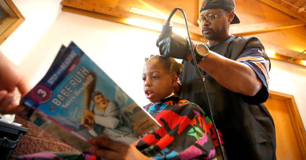 Courtney Holmes is offering free haircuts to kids who read to him as part of a back to school program. Photo: Associated Press