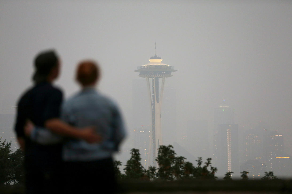 People view the Space Needed as smoke covers the Seattle skyline.