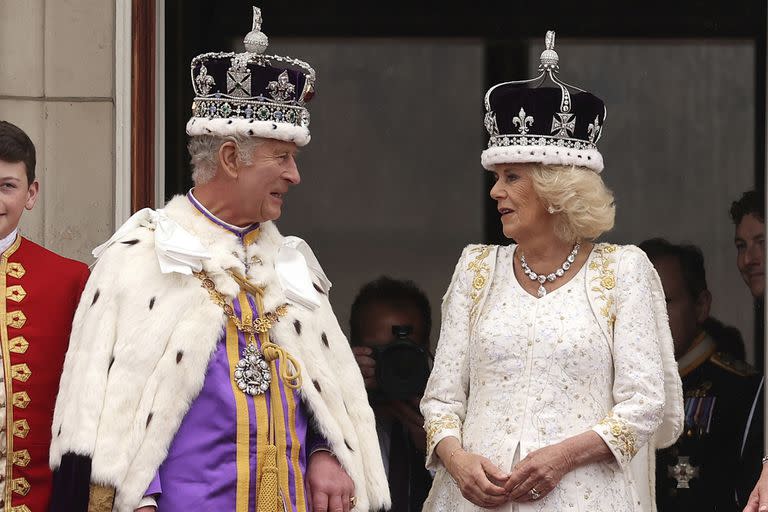 El rey Carlos III de Gran Bretaña habla con la reina Camilla desde el balcón del Palacio de Buckingham tras su ceremonia de coronación, en Londres, el sábado 6 de mayo de 2023