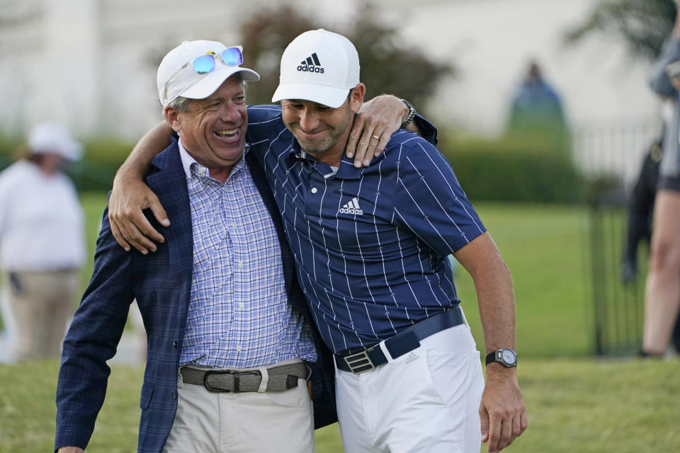 Spain's Sergio Garcia, right, and Steve Jent, executive director of the Sanderson Farms Championship golf tournament, hug one another as they walk to the trophy presentation in Jackson, Miss., Sunday, Oct . 4, 2020. Garcia won by one shot. (AP Photo/Rogelio V. Solis)