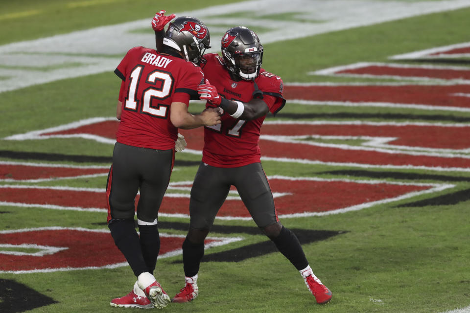 Tampa Bay Buccaneers running back Ronald Jones III (27) celebrates with quarterback Tom Brady (12) after scoring on a 37-yard touchdown pass during the first half of an NFL football game against the Kansas City Chiefs Sunday, Nov. 29, 2020, in Tampa, Fla. (AP Photo/Mark LoMoglio)