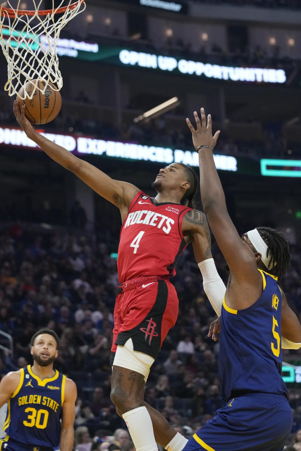 Houston Rockets guard Jalen Green (4) shoots next to Golden State Warriors center Kevon Looney (5) during the first half of an NBA basketball game in San Francisco, Saturday, Dec. 3, 2022. (AP Photo/Godofredo A. Vásquez)