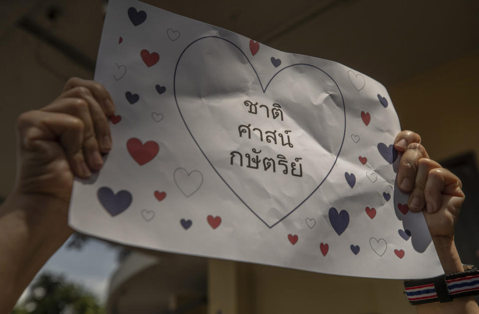 A supporter of Thailand's monarchy hold a poster that reads " Nation, Religion, and Monarchy", during a gathering to show concerns over the country's pro-democracy movement, which they feel besmirches the royal institution in Bangkok, Thailand, Thursday, July 30, 2020. The demonstration was held at Democracy Monument, a traditional venue for protests of all political stripes that in recent weeks has hosted several larger pro-democracy, anti-government protests organized by students. (AP Photo/Sakchai Lalit)