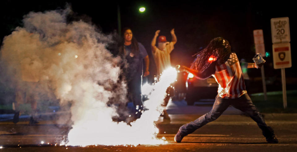 Edward Crawford tosses a tear gas canister fired by police who were trying to disperse protesters in Ferguson, Missouri, on Aug. 13, 2014.&nbsp; (Photo: Photo by Robert Cohen/St. Louis Post-Dispatch)