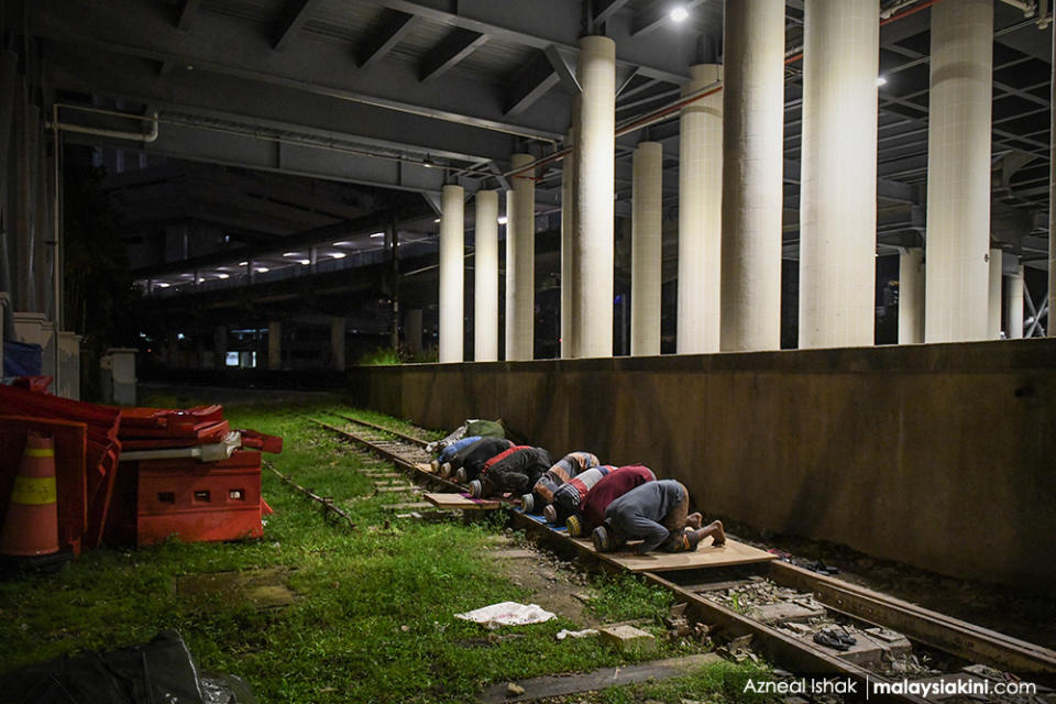 Foreign workers perform tarawih prayers at an LRT rail as Muslims mark Ramadan while coping with the Covid-19 pandemic in Kuala Lumpur on Apr 29, 2020.