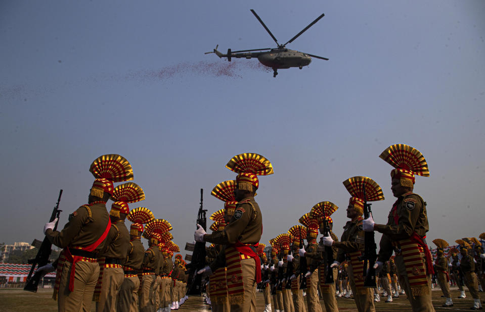 An Indian air force helicopter sprays flower petals as Sashastra Seema Bal paramilitary soldiers participate in a parade to mark Republic Day in Gauhati, India, Sunday, Jan. 26, 2020. Sunday's event marks the anniversary of the country's democratic constitution taking force in 1950. (AP Photo/Anupam Nath)