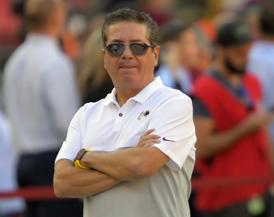 Dan Snyder stands on a football field.